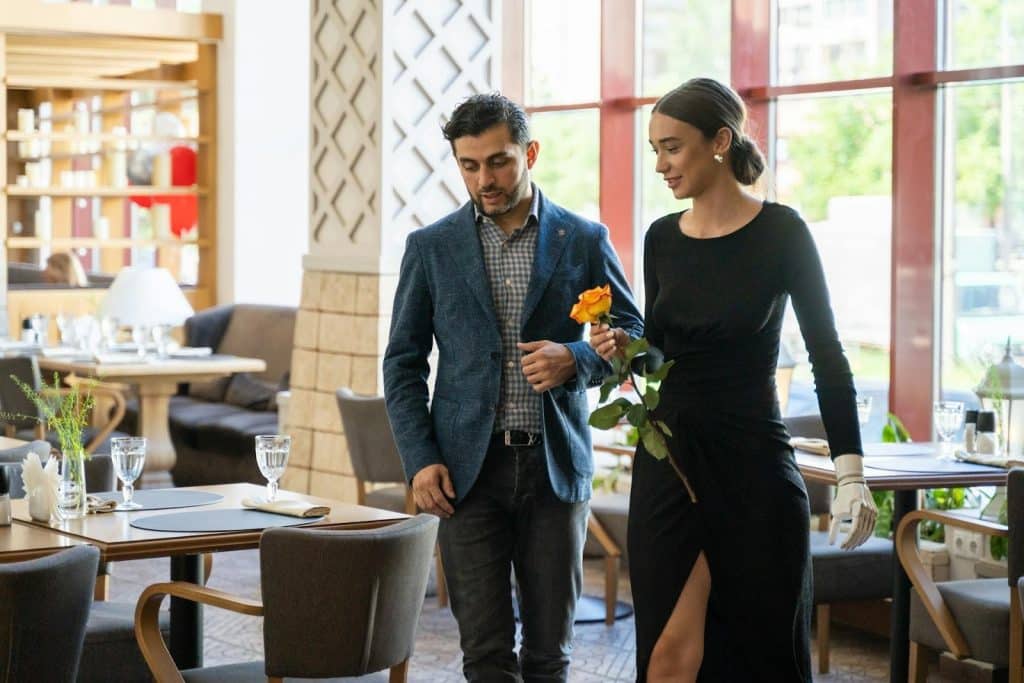 The man is walking with a woman holding a rose.