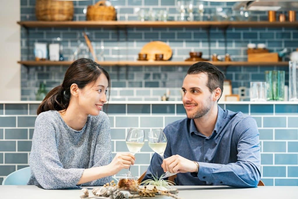 The couple is toasting while looking at each other.