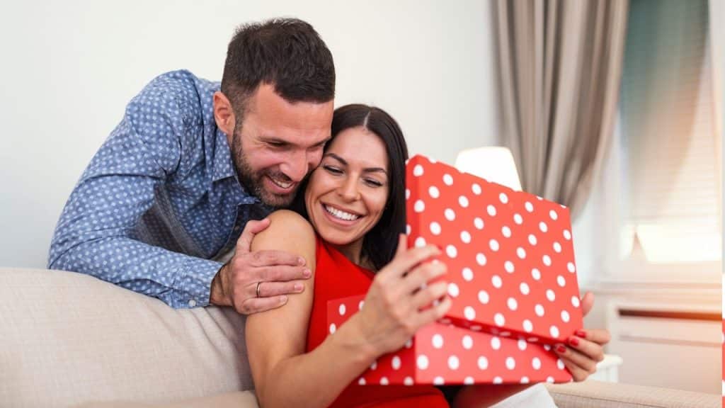 A man surprising his wife by giving a present on Valentine's Day.