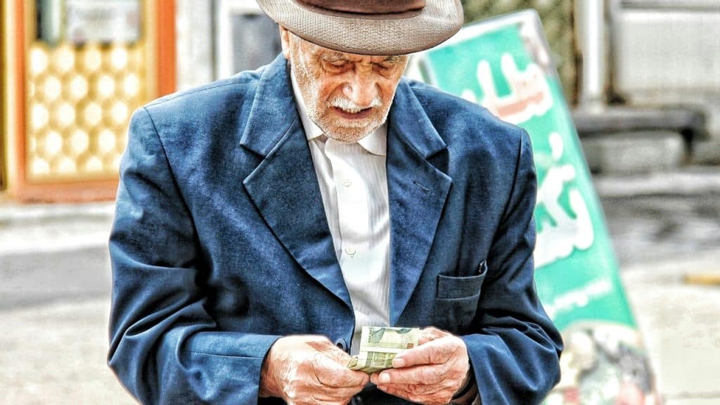 A man in a hat holding money in his hands.