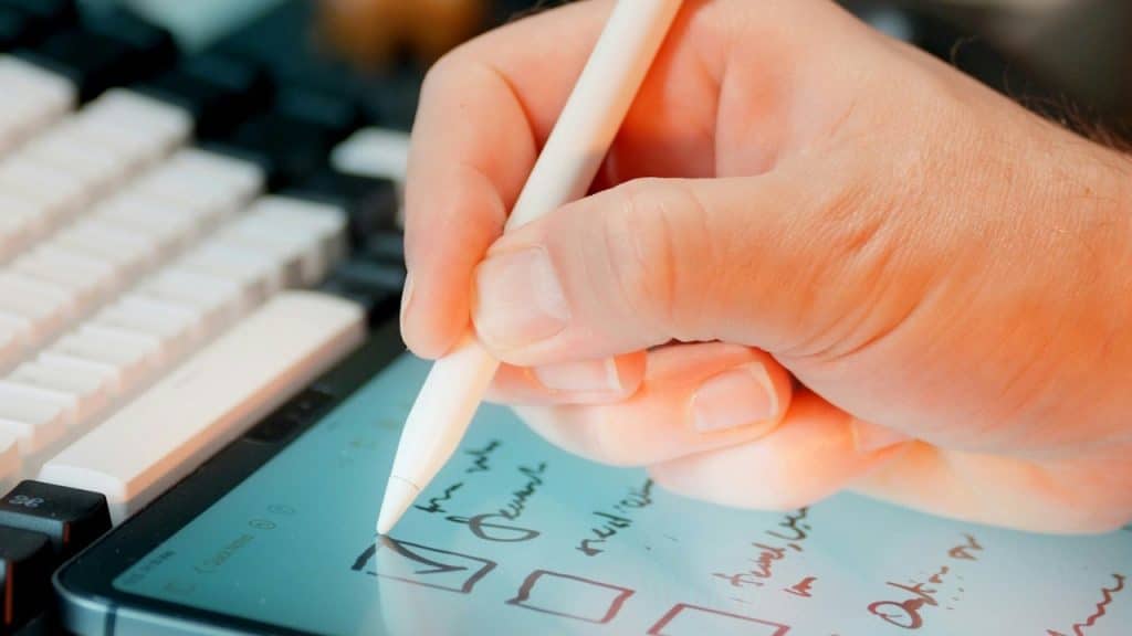 A person using a pen to tick off on a checklist.