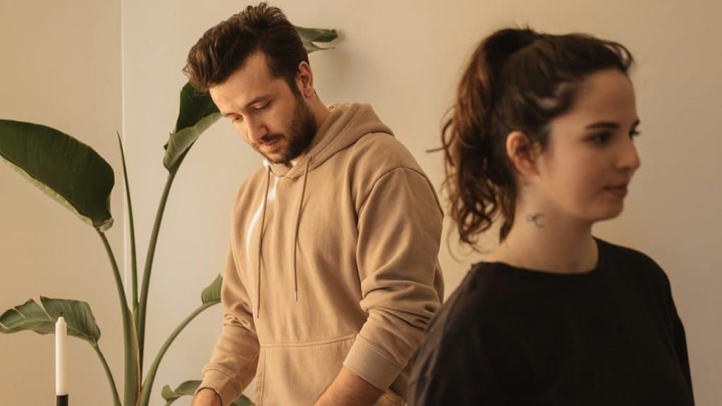 A man looking down while a woman ignores him.