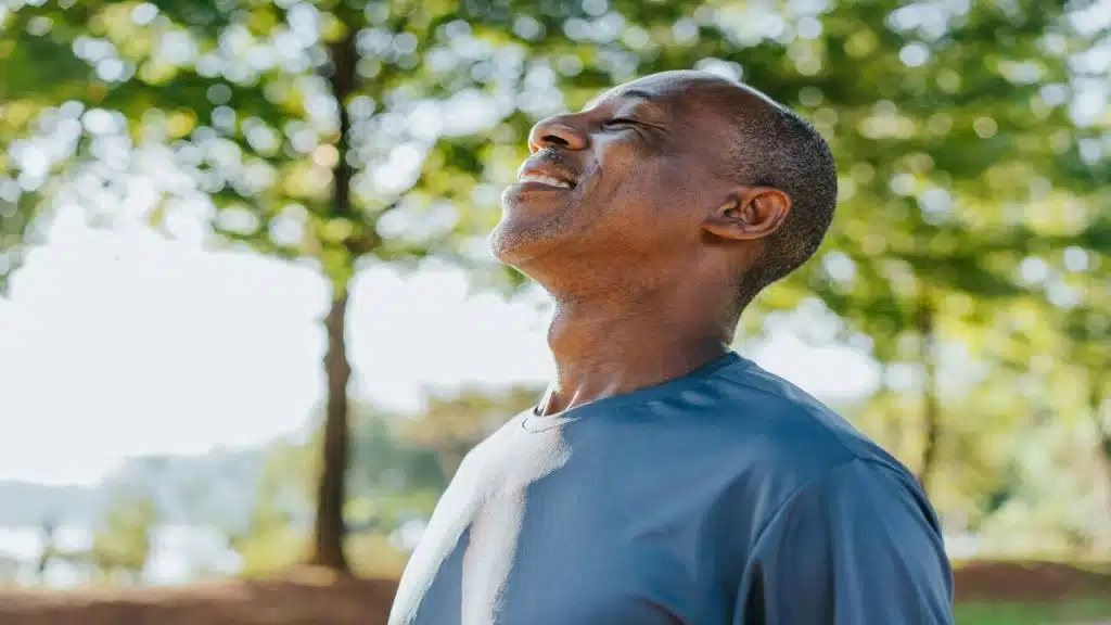 A man taking a deep breath outdoors