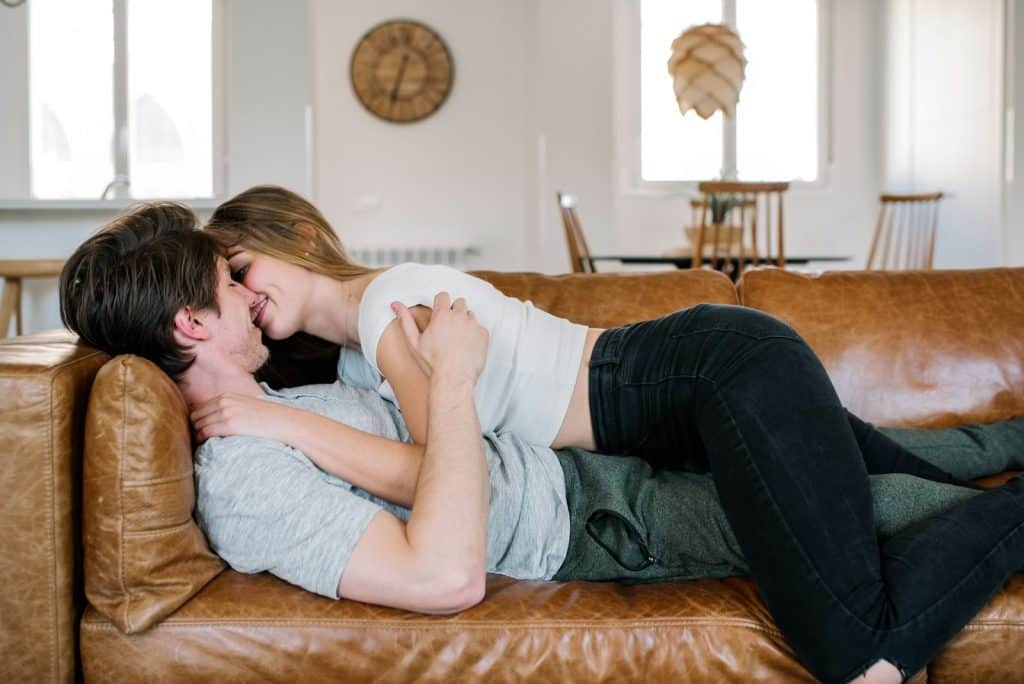 The couple is cuddling on the couch.