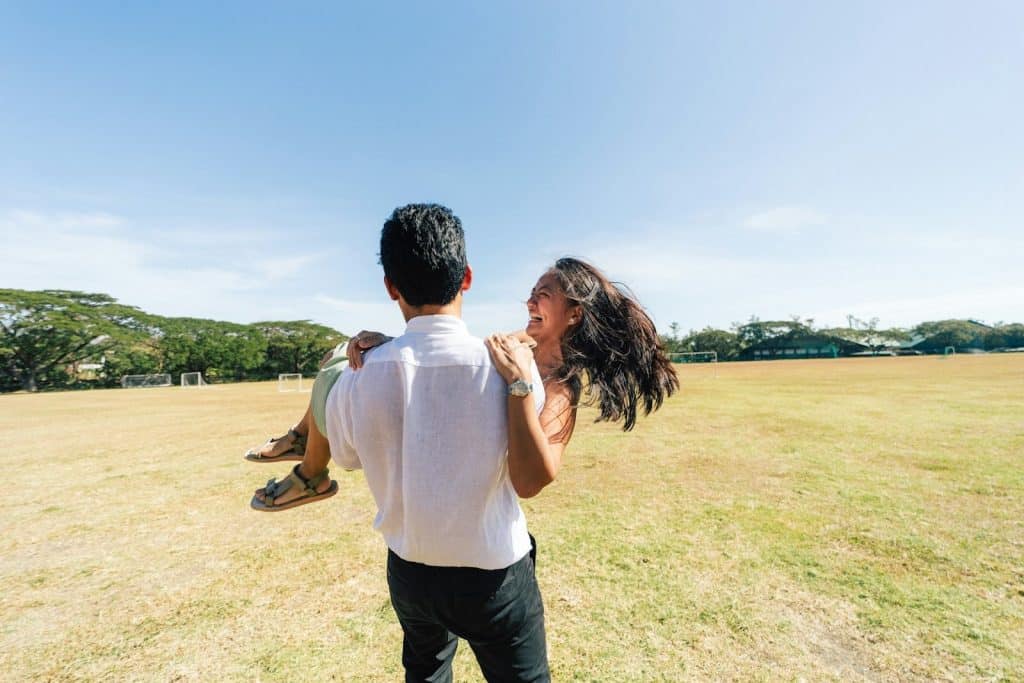 The man is carrying the laughing woman.