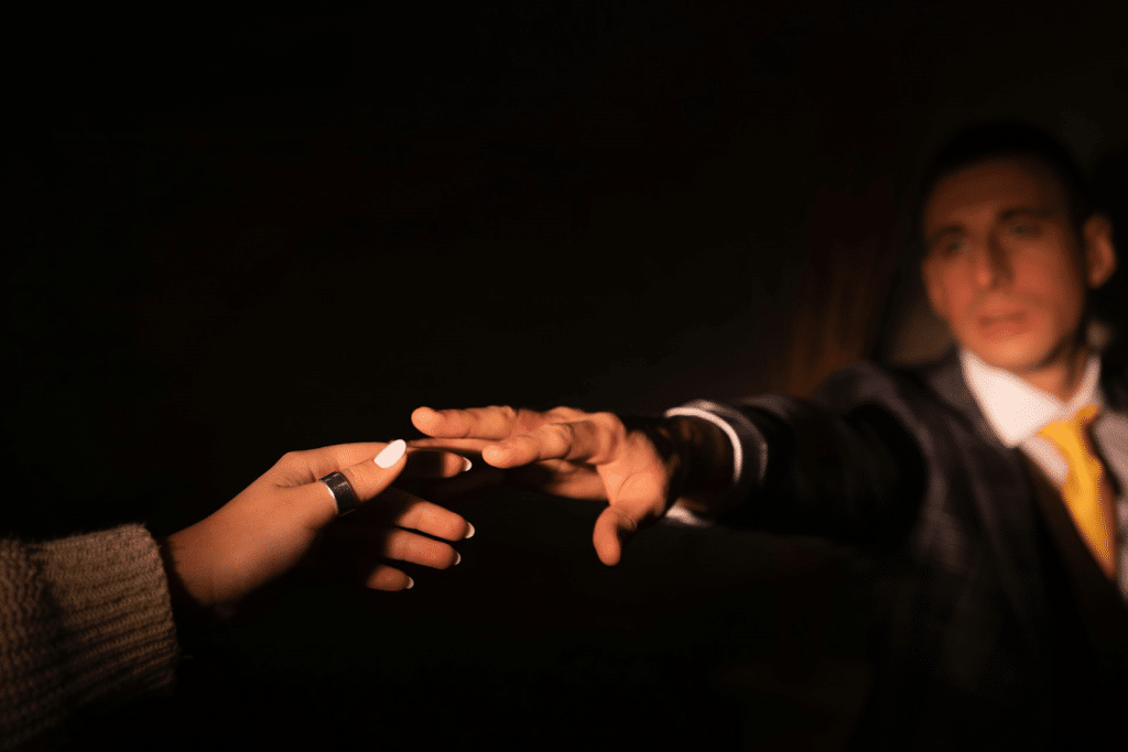 A couple tries to hold each other's hand.