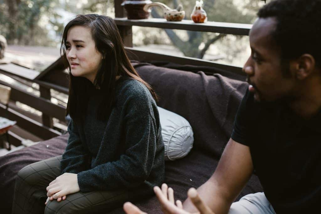 A man sitting beside a crying woman.