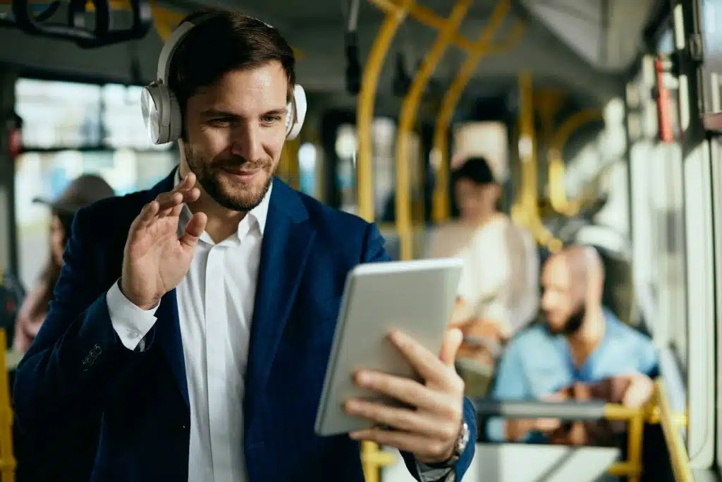 A man waving on a video call while commuting to work.
