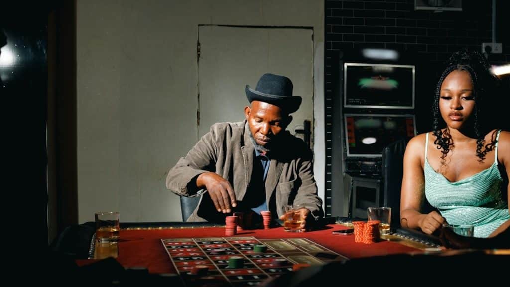 A man playing poker while his unattended wife is feeling neglected.