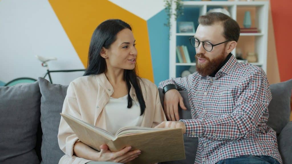 A couple looking at an old photo album together.