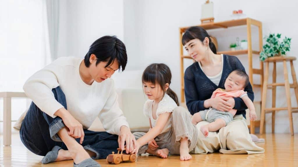 A couple playing with their kids indoors.