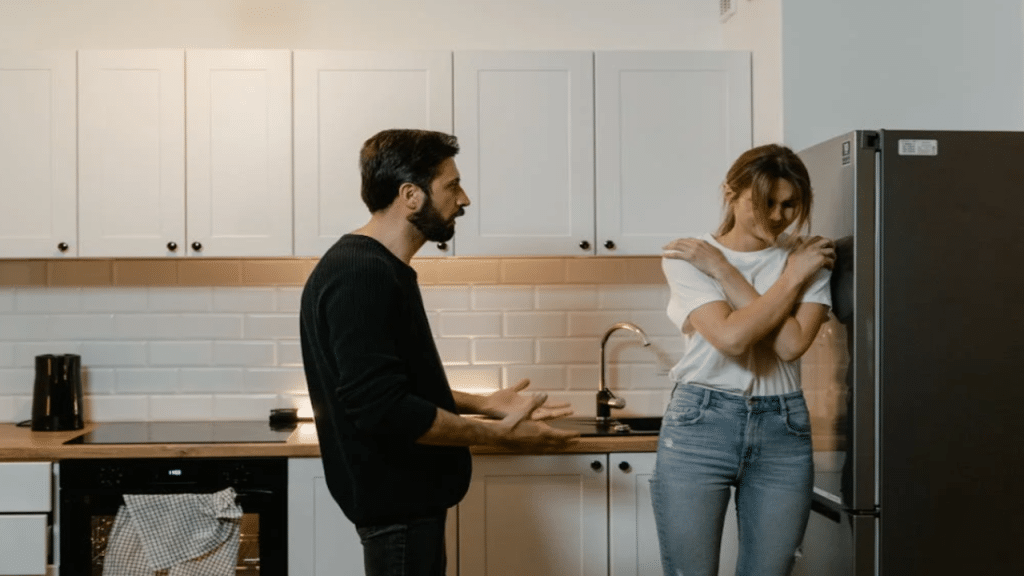 A man confronting his wife in the kitchen