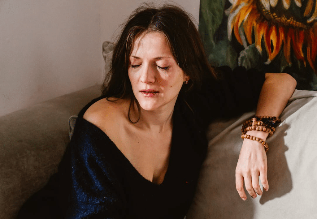 A Woman Sitting on a Couch Crying