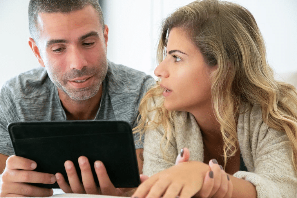Man Holding Tablet While Talking to a Woman