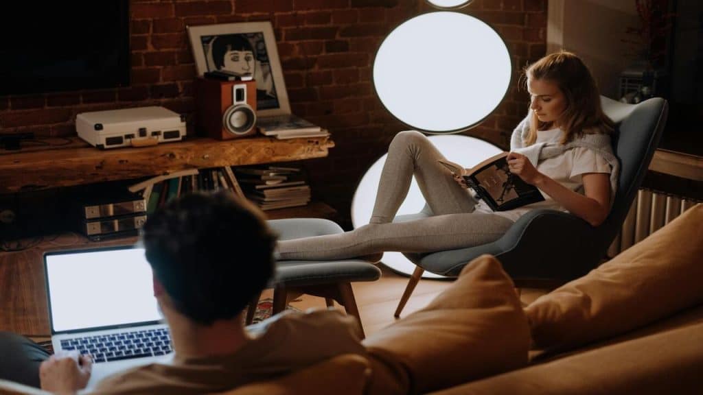 A couple doing their own thing in the living room