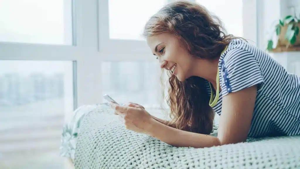 A woman smiling while texting