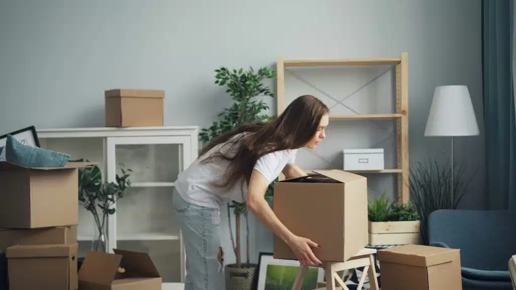 A woman carrying moving boxes