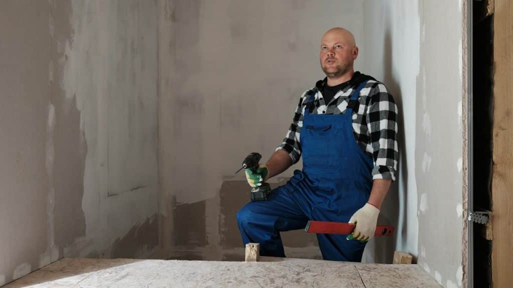 A man holding a drill and a hammer.