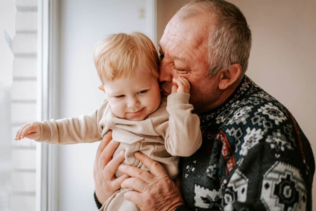 An older man holding a baby.