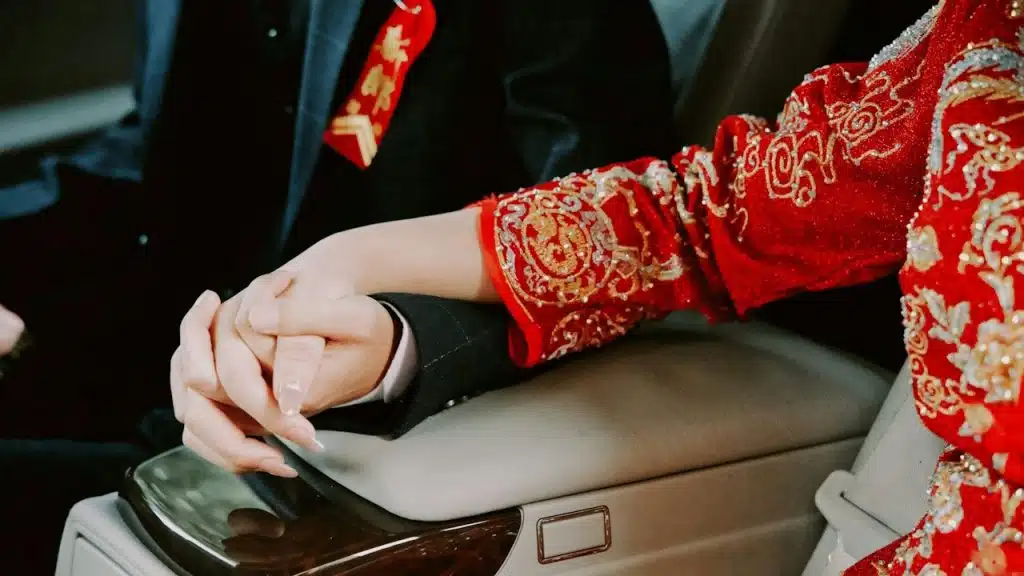 A man holding a woman’s hand in a car.