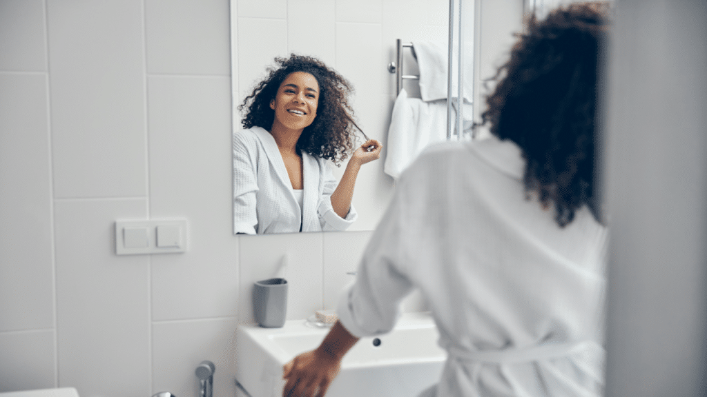 A woman smiling at herself in the mirror