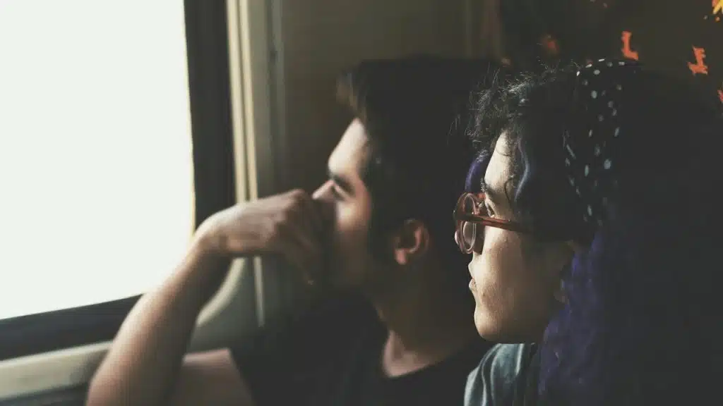A man and a woman looking out of the window.