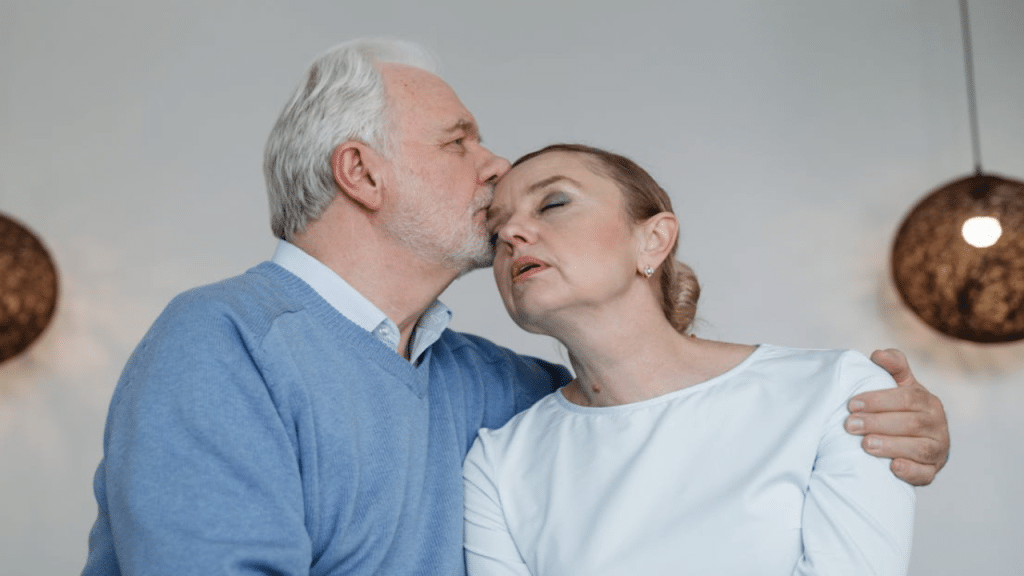 A man kissing his upset wife on the temple