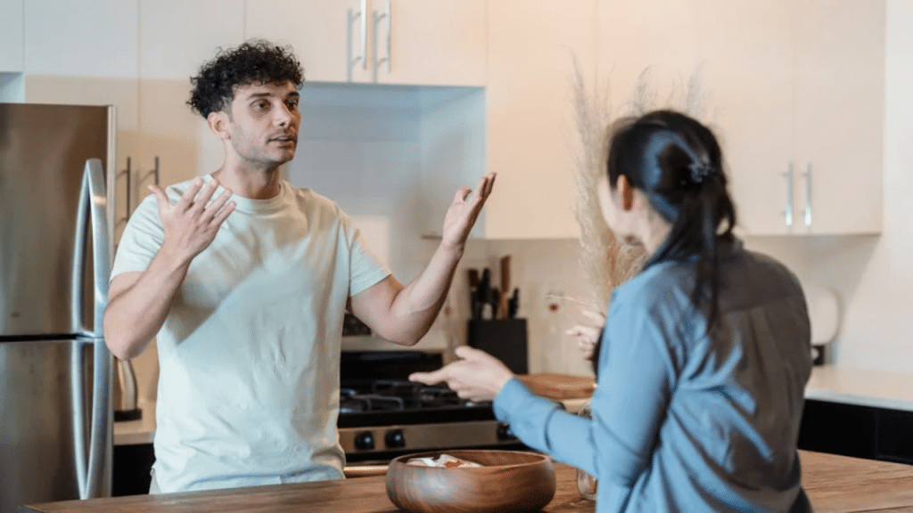 A man berating his wife in the kitchen