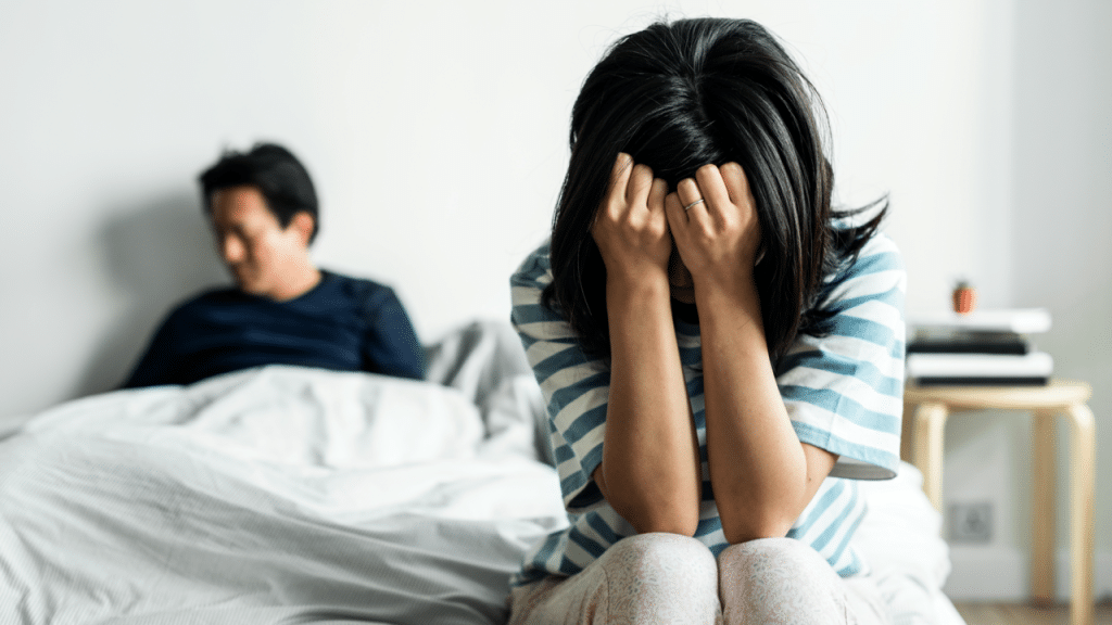 A woman looking upset in the bedroom