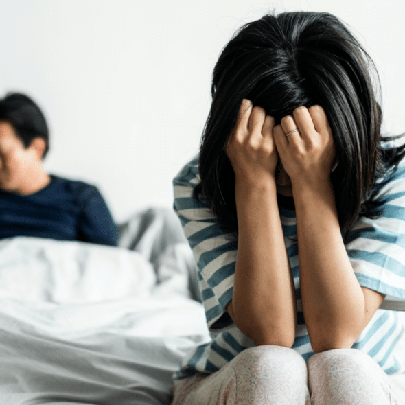 A woman looking upset in the bedroom
