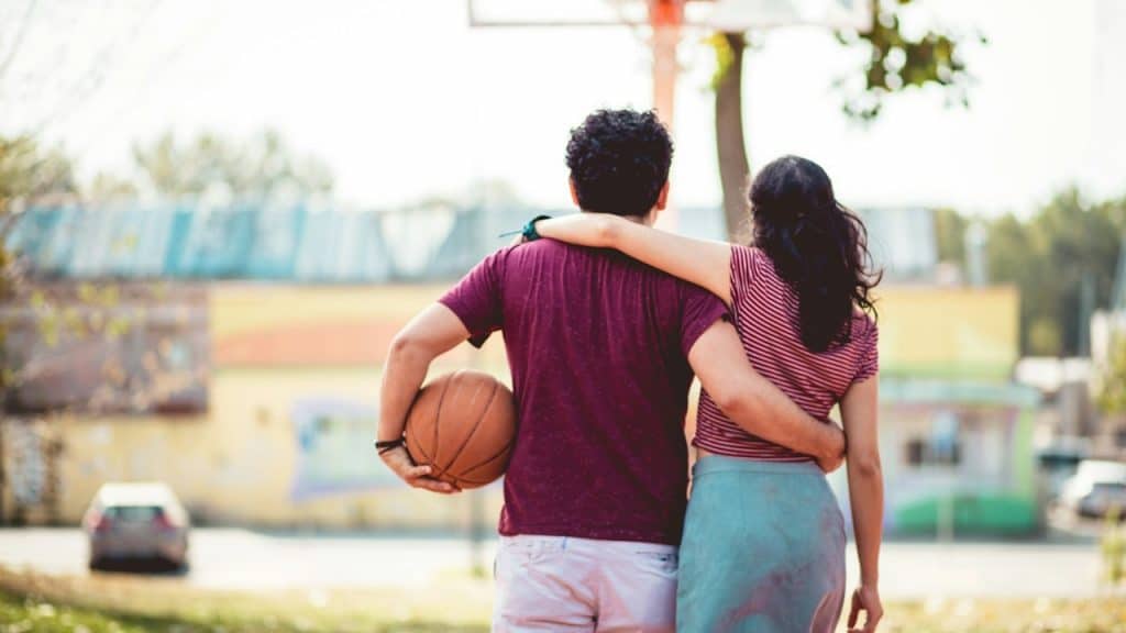 Couple with a ball on a basketball court.