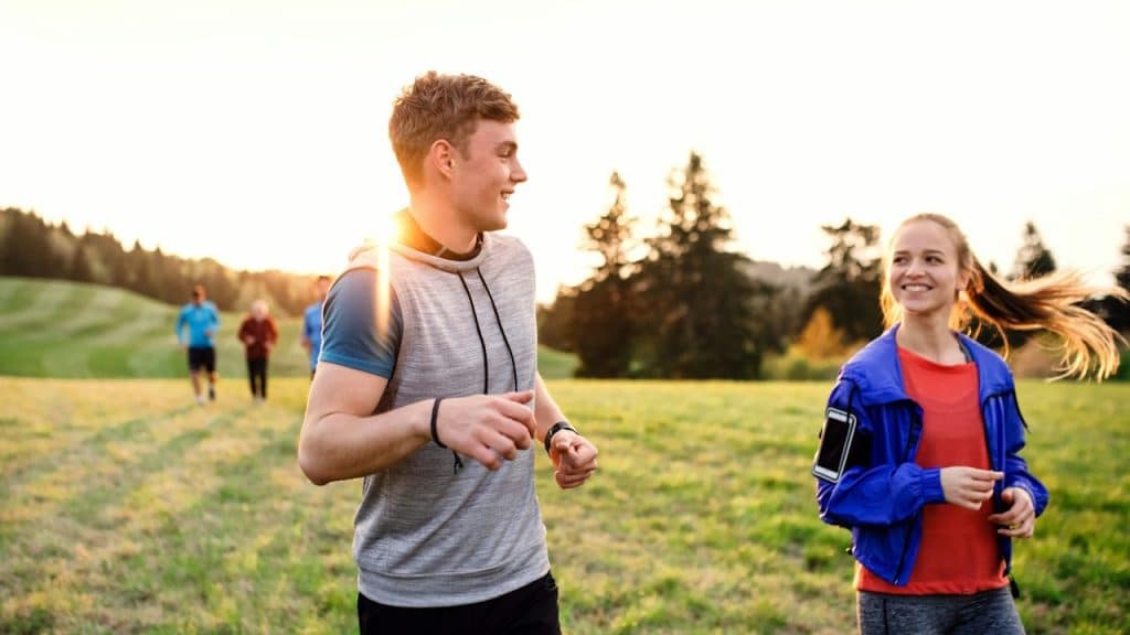 A young couple running in nature.