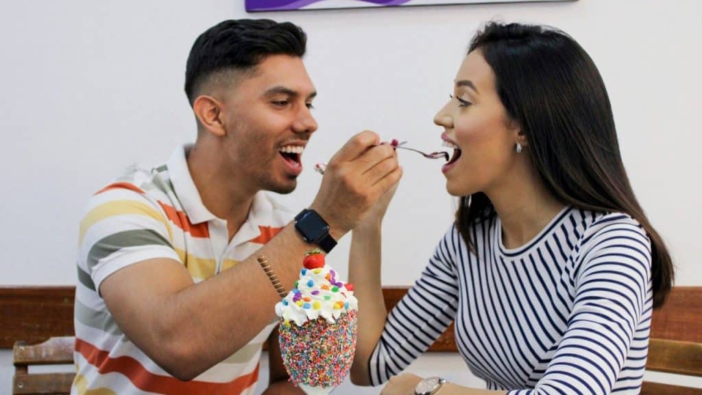 A man and woman feeding each other.