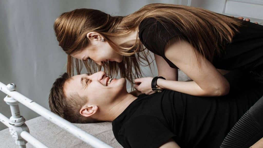 A couple smiling at each other in bed