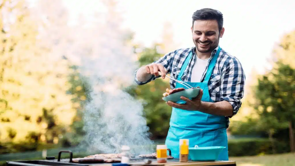 A man laughing while cooking