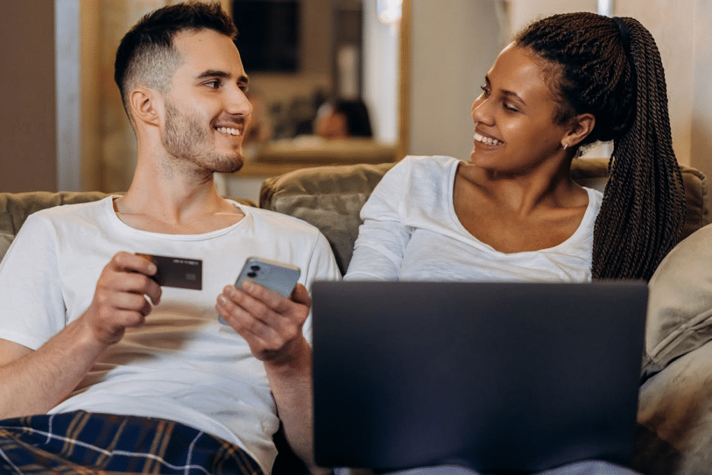 A Couple Sitting on the Couch while Doing Online Shopping