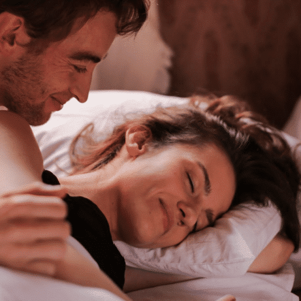 A couple smiling in bed