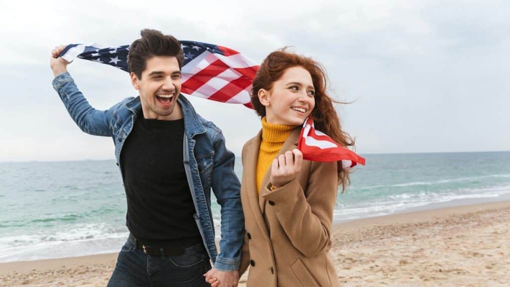 A man and a woman walking on a beach.