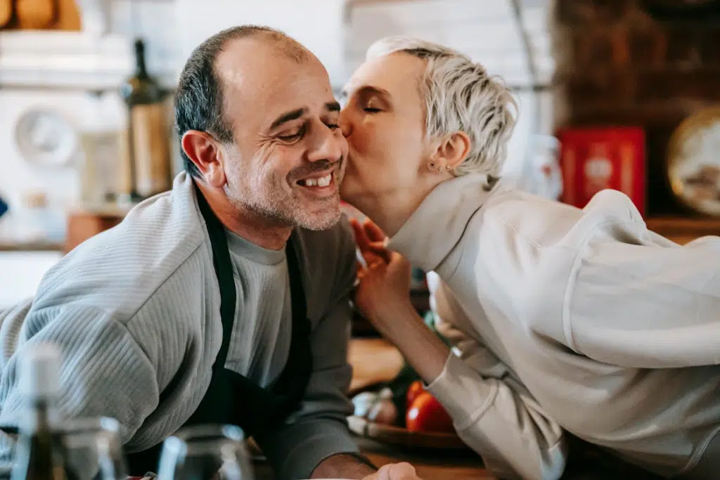 A woman kissing a man on the cheek