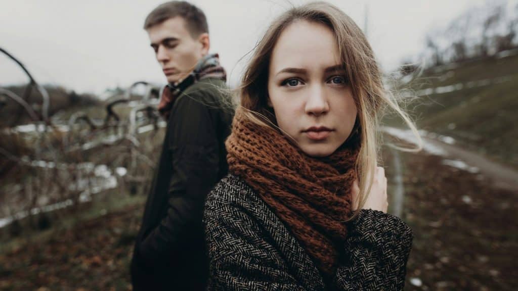 A sad couple standing outdoors.