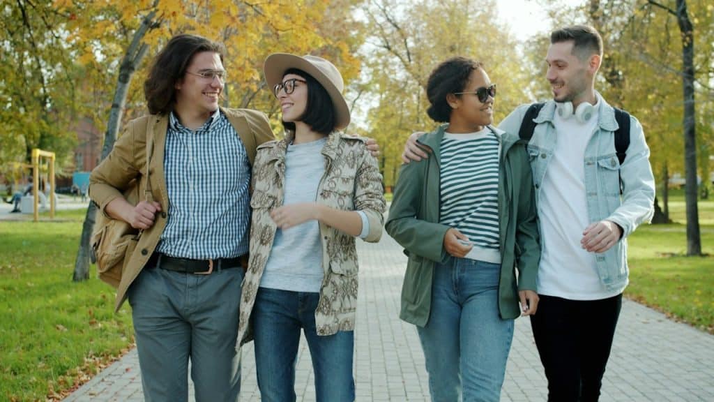 Two couples walking in a park.
