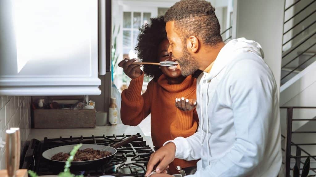 A woman feeding her husband with chopsticks.