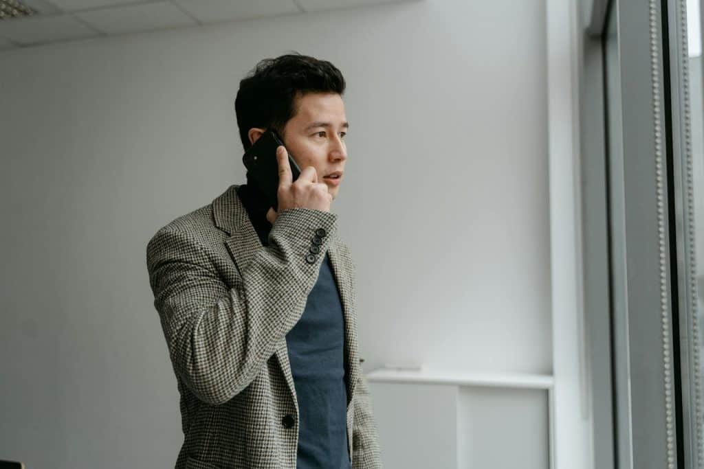 The man is calling someone on his smartphone.