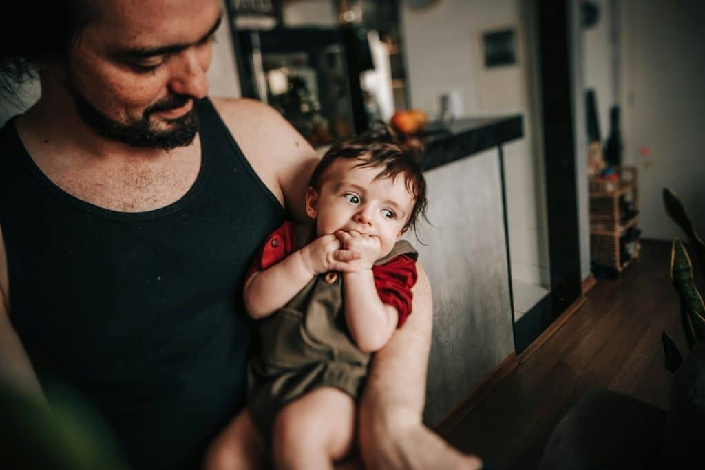 The father is carrying his son.