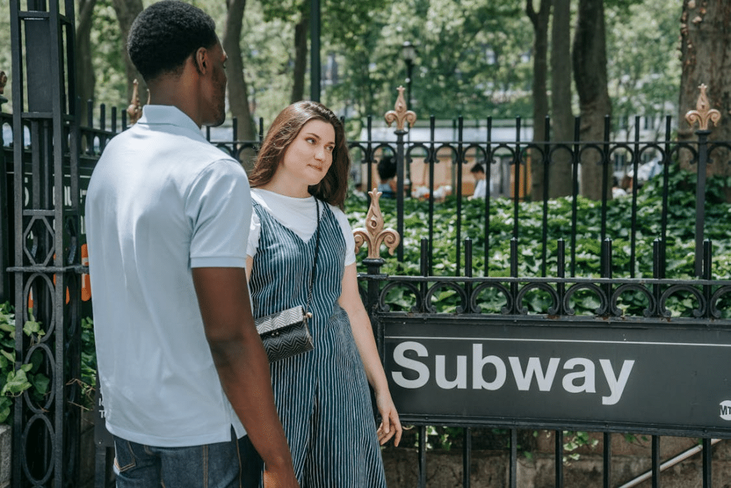 Woman Standing Beside a Subway Signage