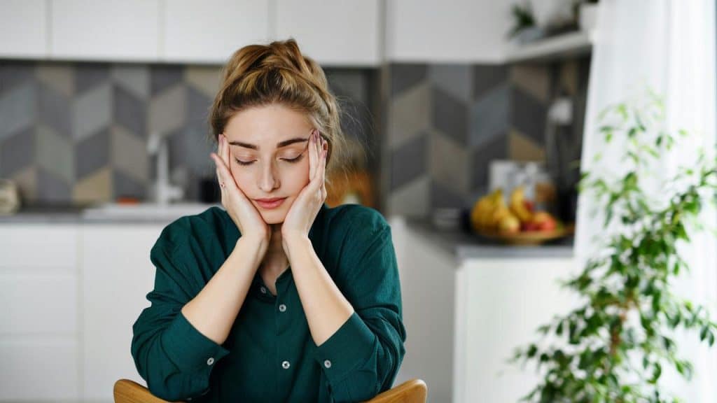 A woman sitting with her face resting in her hands.