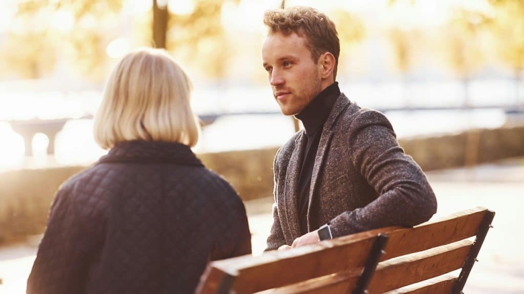 A couple sitting on a bench in a park.