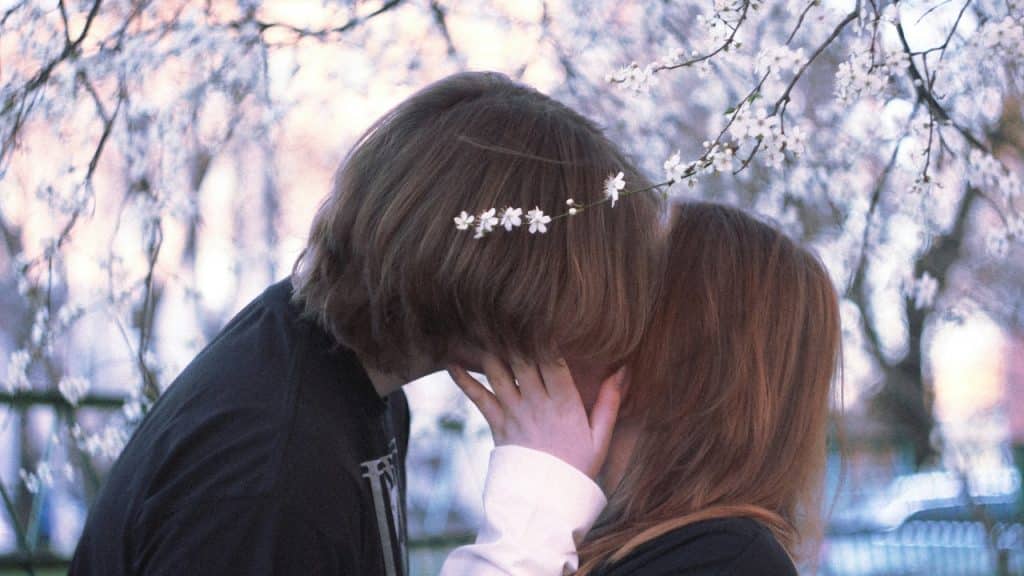 A couple shares a sweet romantic kiss.