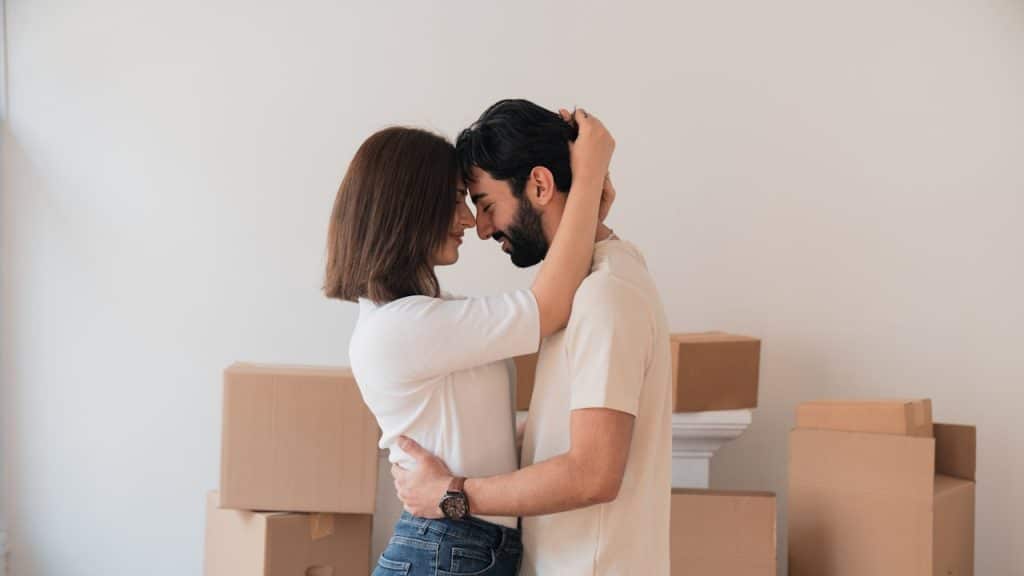 A man and woman embracing and touching foreheads after moving into a new home.