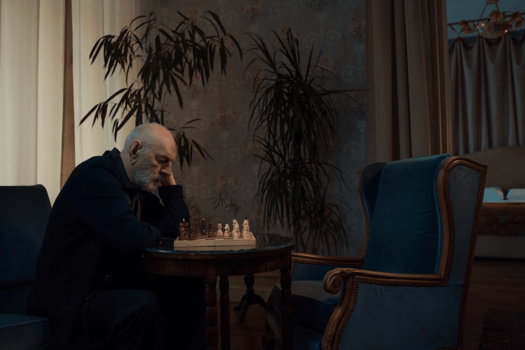 An Elderly Man Playing Chess Alone